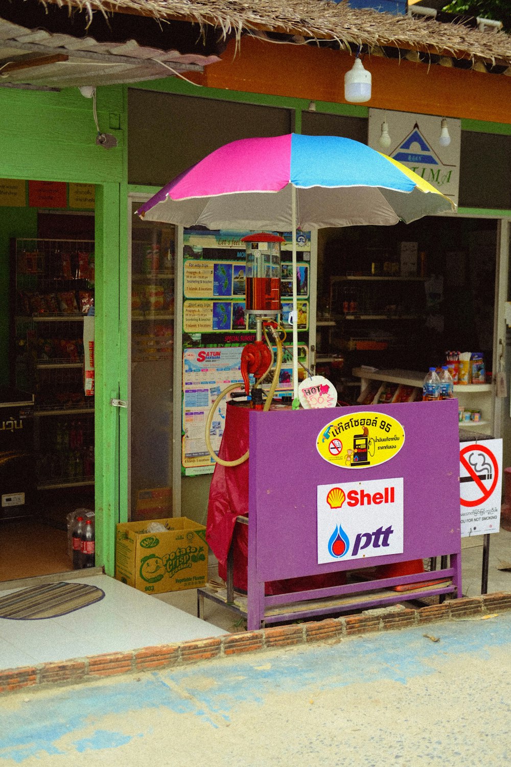 a store with a purple bench and a blue and white umbrella