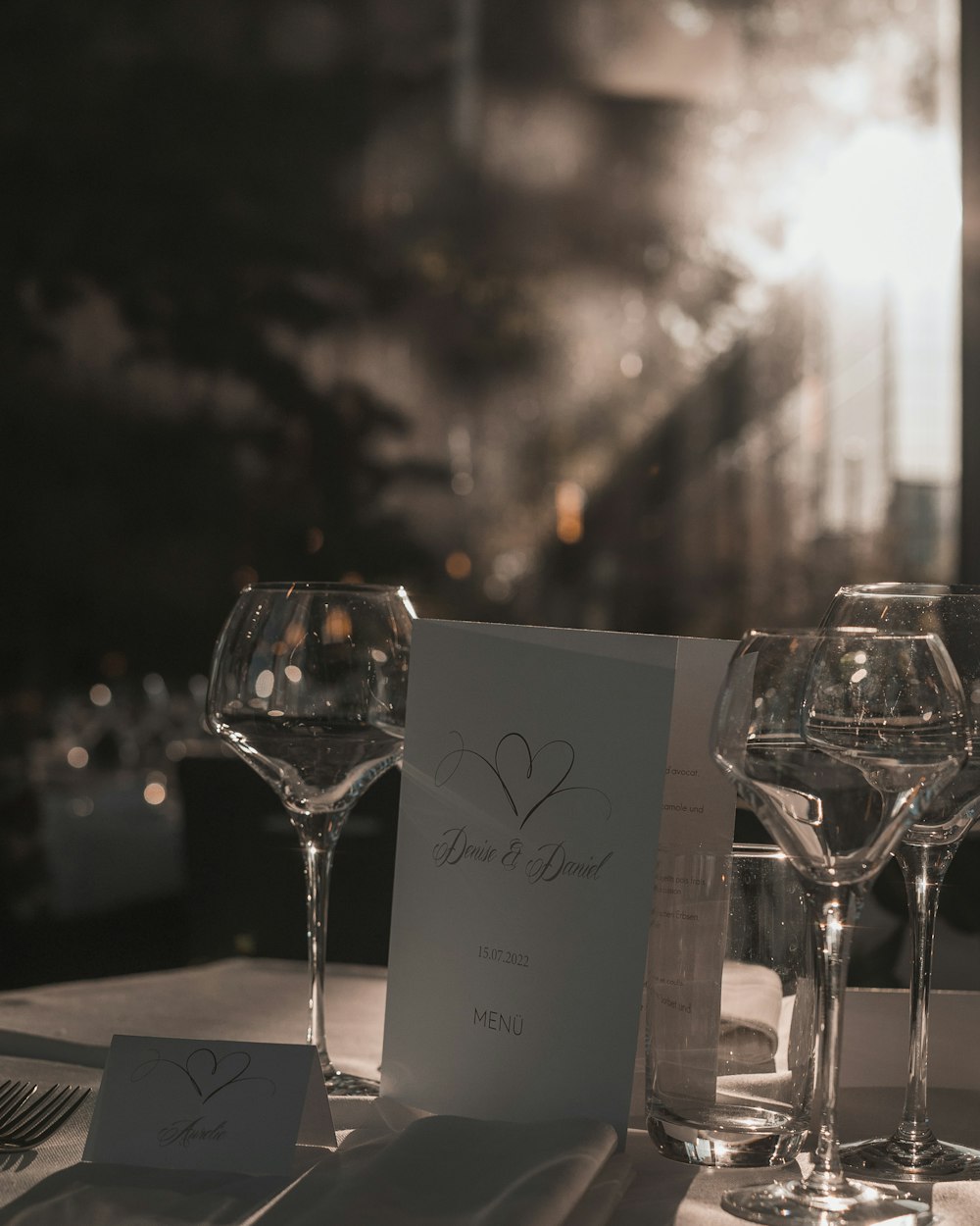 a table with wine glasses and a card on it