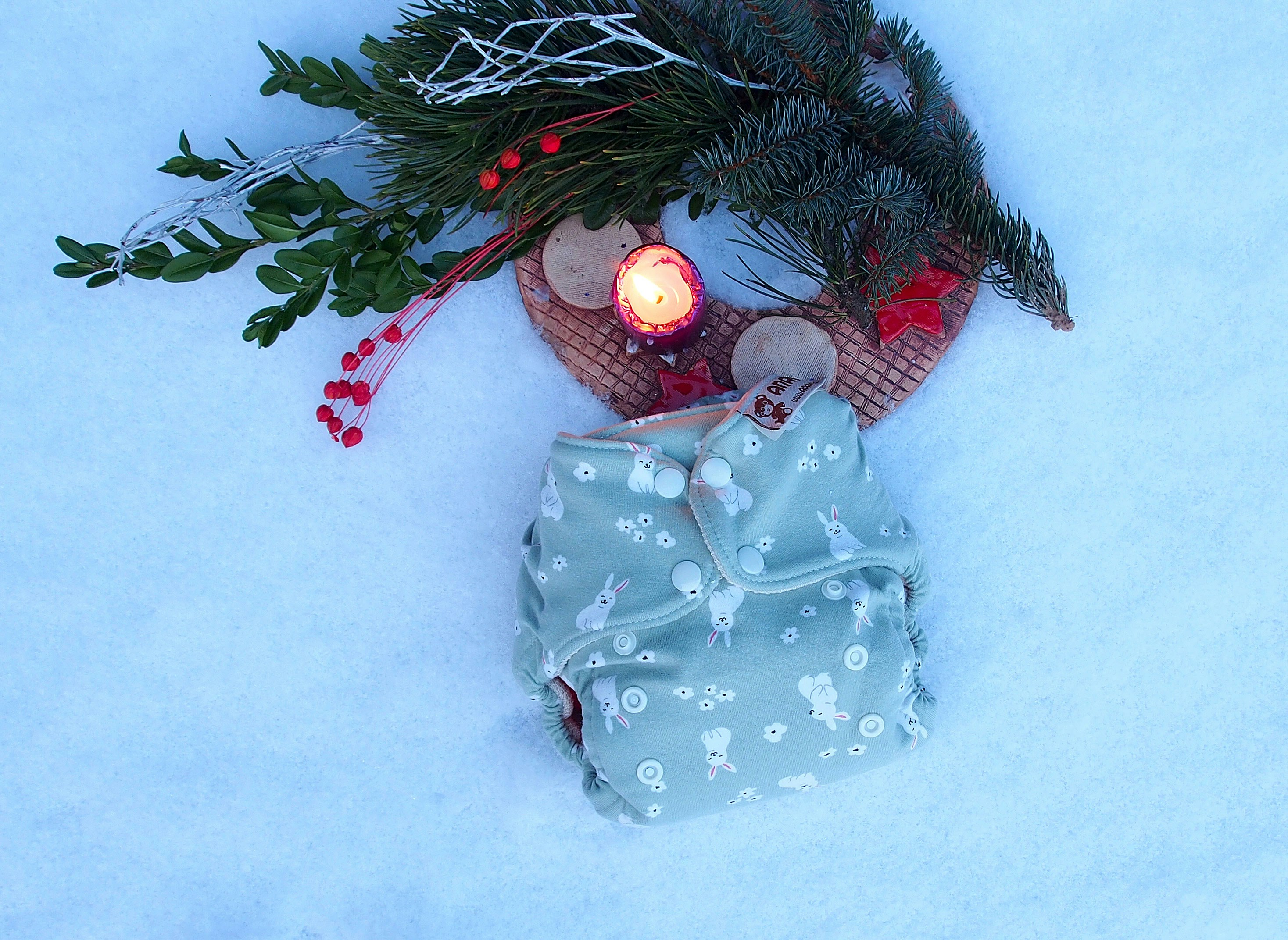 a cloth diaper next to a candle in the snow
