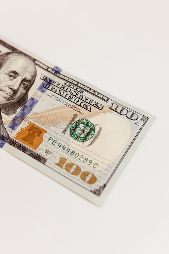 a one hundred dollar bill laying on top of a white table