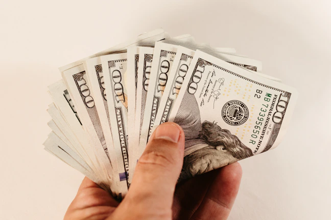 Close-up of crisp US dollar bills fanned out on a wooden table