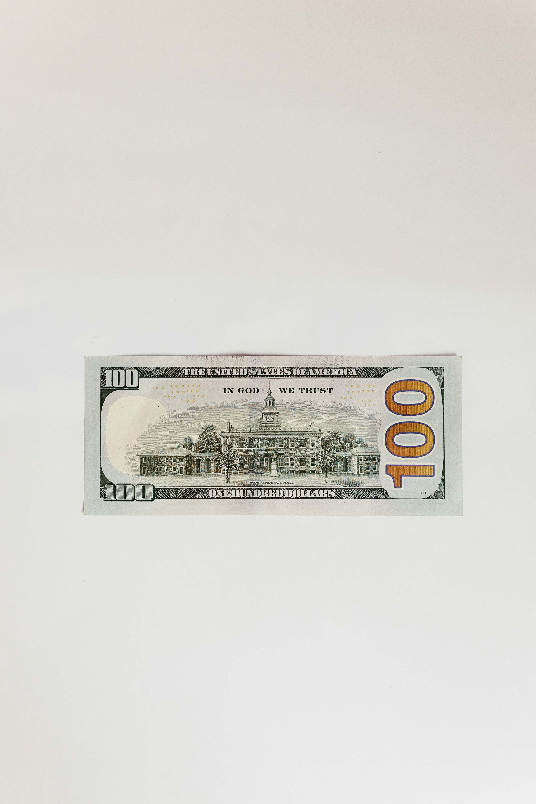 a one hundred dollar bill hanging from a wall