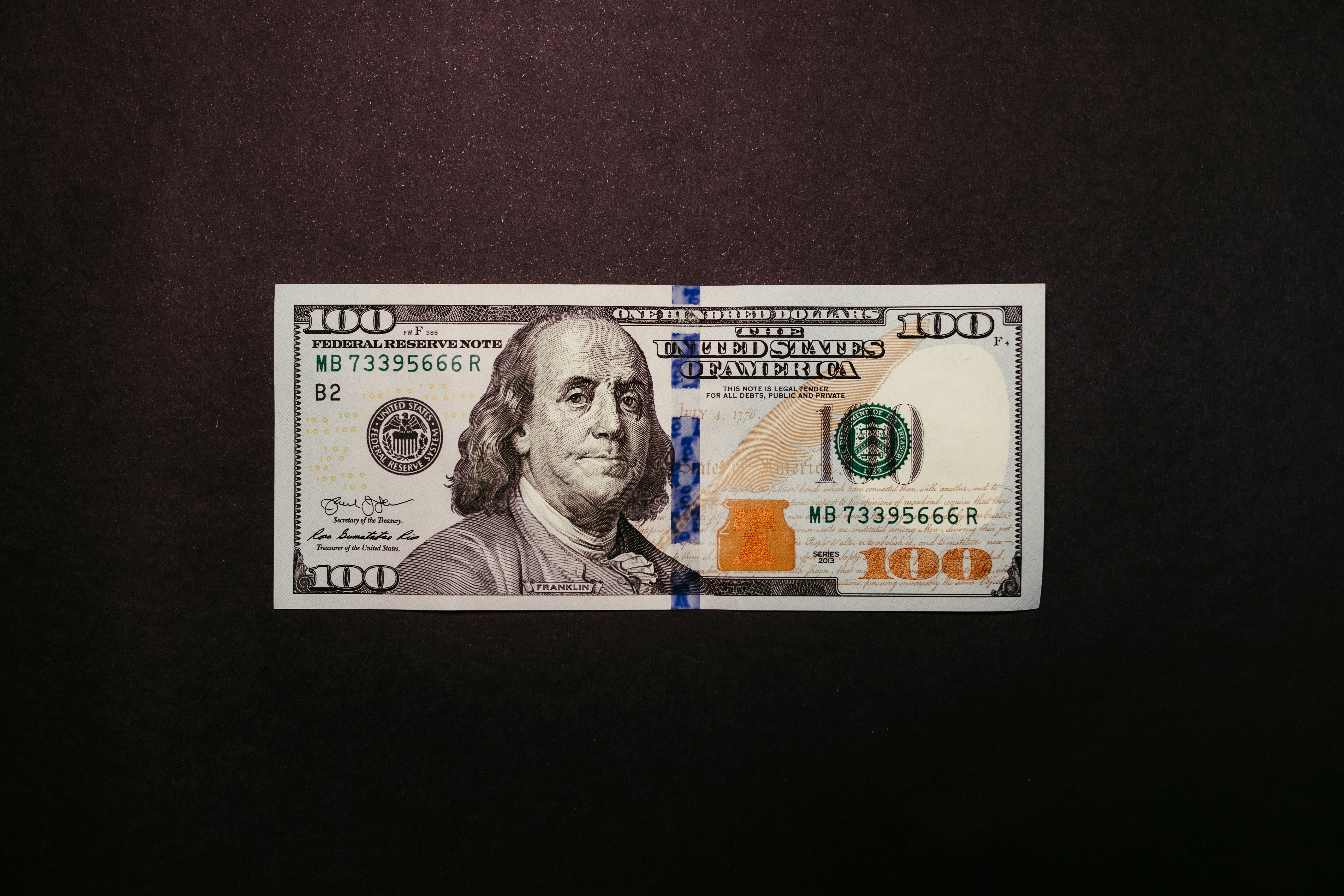 a one hundred dollar bill laying on top of a table