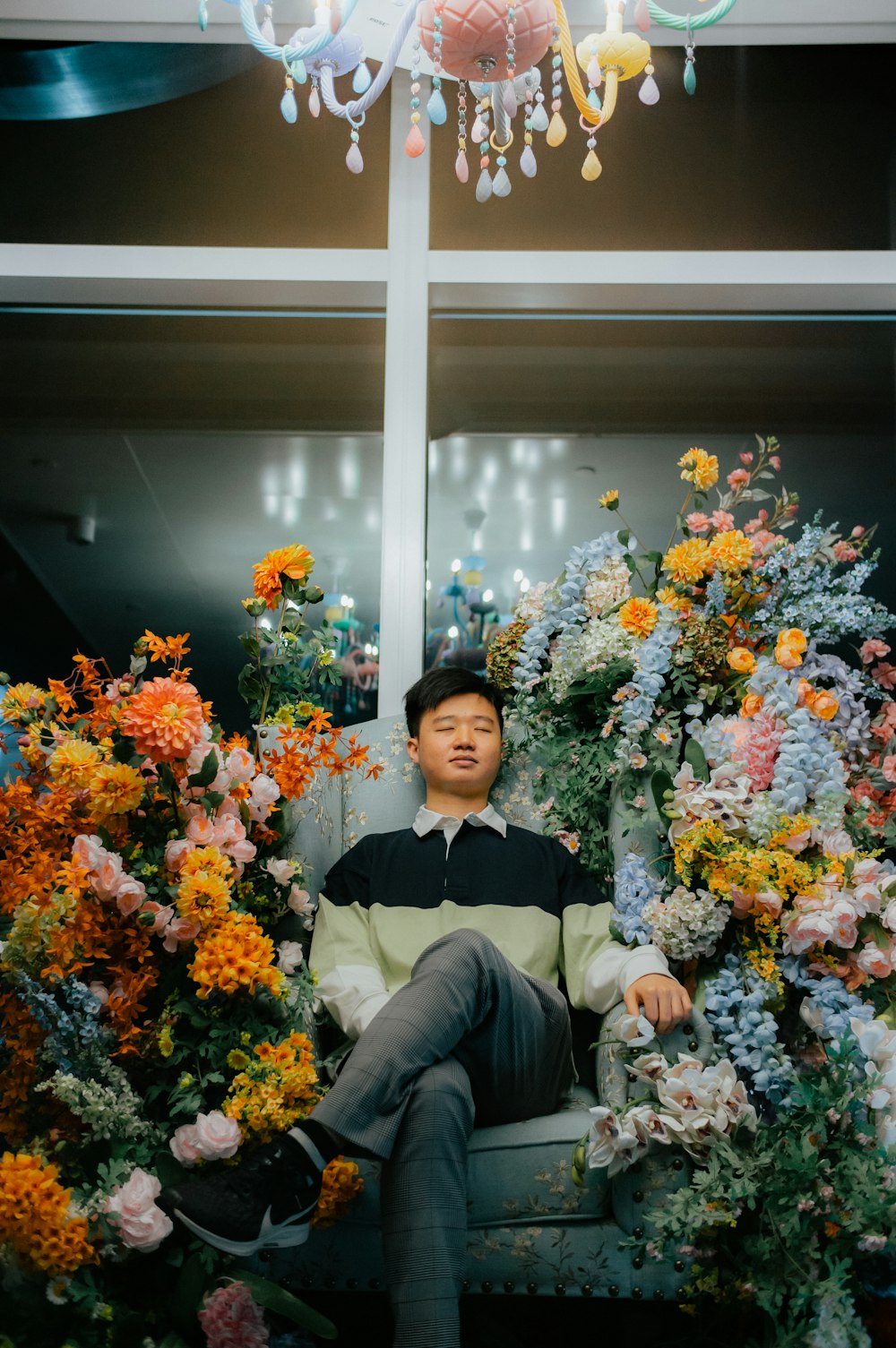 a man sitting in a chair surrounded by flowers