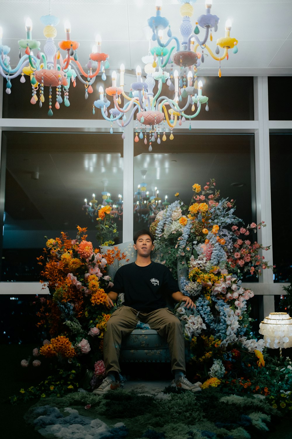 a man sitting on a chair in front of a chandelier