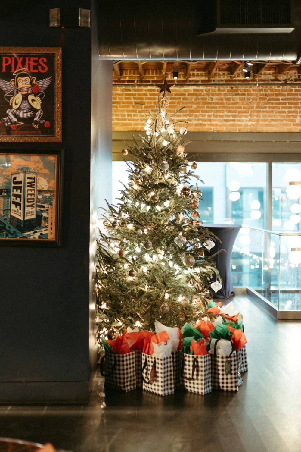 a small christmas tree in a room with pictures on the wall