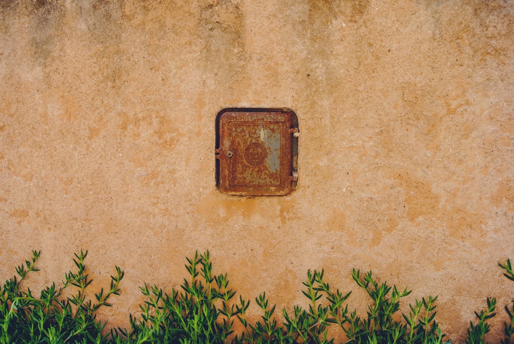 a rusted metal box sitting on the side of a wall