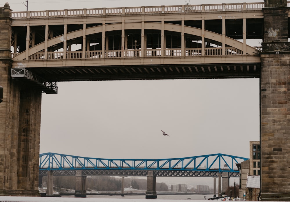 an airplane flying over a bridge on a cloudy day