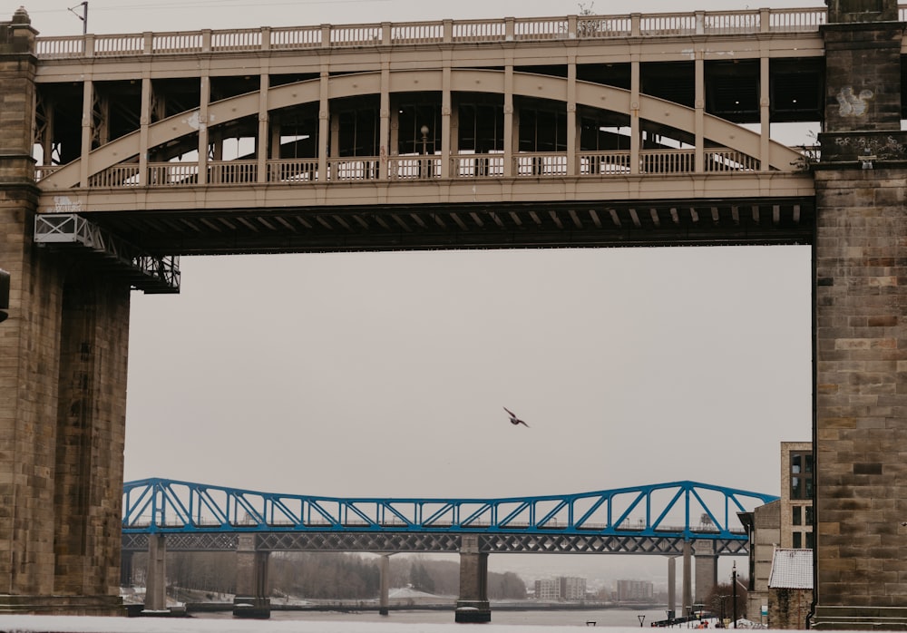 Un avión sobrevolando un puente en un día nublado