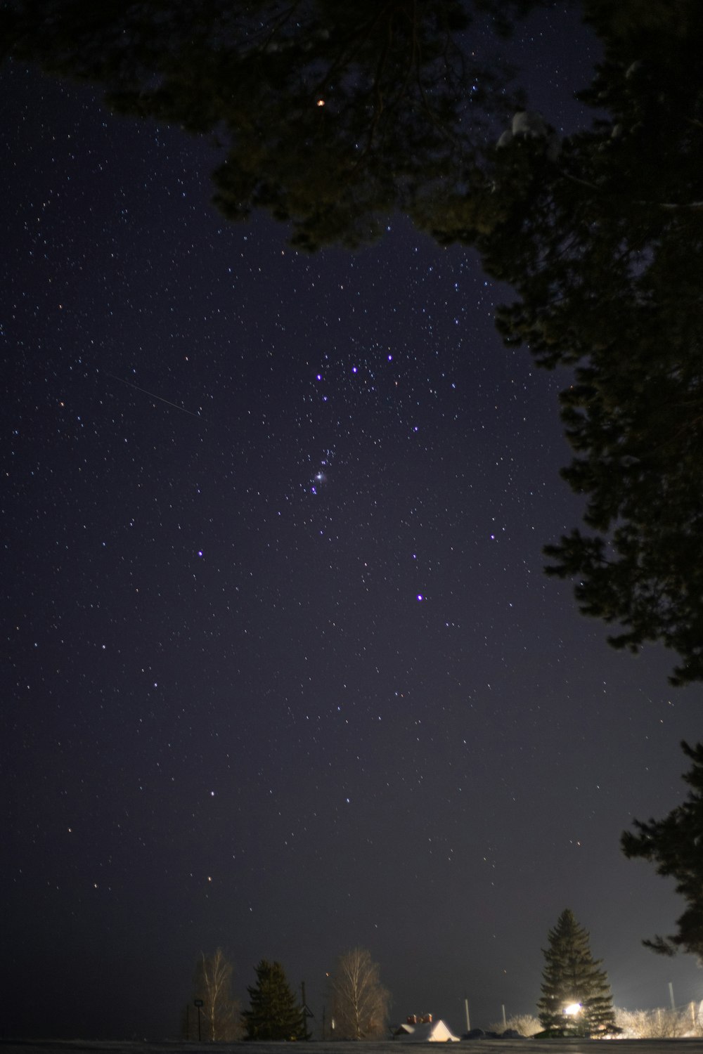 the night sky with stars above a snow covered field