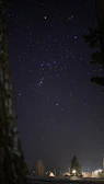 A close-up of an oil painting showing the Orion constellation glowing softly against a deep navy background.