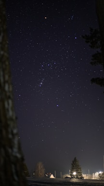 A serene night sky with glowing stars forming zodiac constellations over Hyderabad cityscape.
