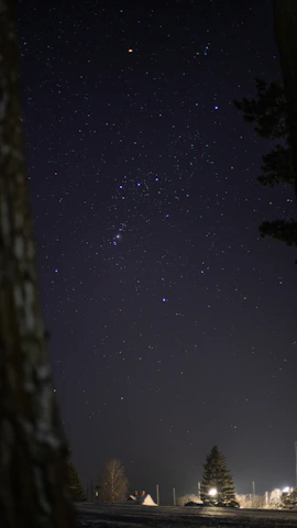 Close-up of an oil painting depicting the Orion constellation glowing against a deep midnight blue sky.