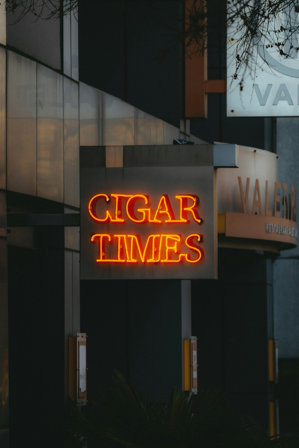 a neon sign that reads cigar times on a building