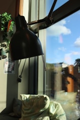 Modern desk area with a lamp and chair beside the hotel room window.