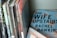 A collection of books is neatly arranged on a shelf. The titles include works by authors such as Lovecraft, Koontz, and Celia Rees. A hardcover book titled 'The Wife Upstairs' by Rachel Hawkins is prominently displayed, lying flat with a blue cover featuring large bold lettering and floral designs.