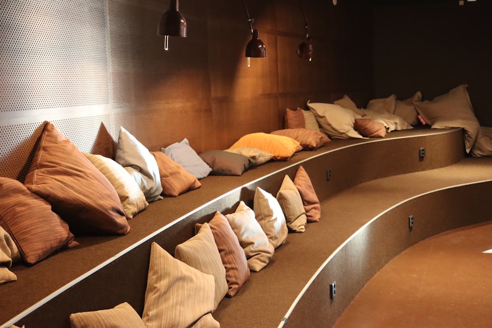 a row of pillows sitting on top of a curved bench