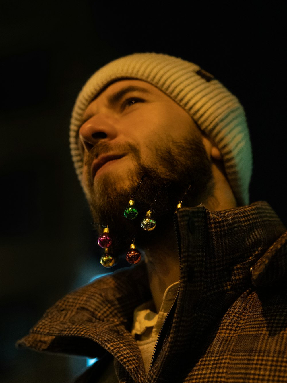 a man with a beard wearing a beanie and earrings