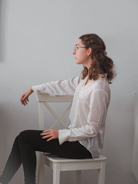 a woman sitting on a chair with her legs crossed