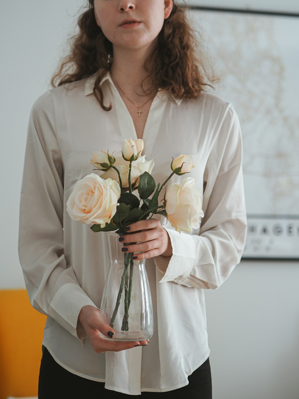 a woman holding a vase with flowers in it