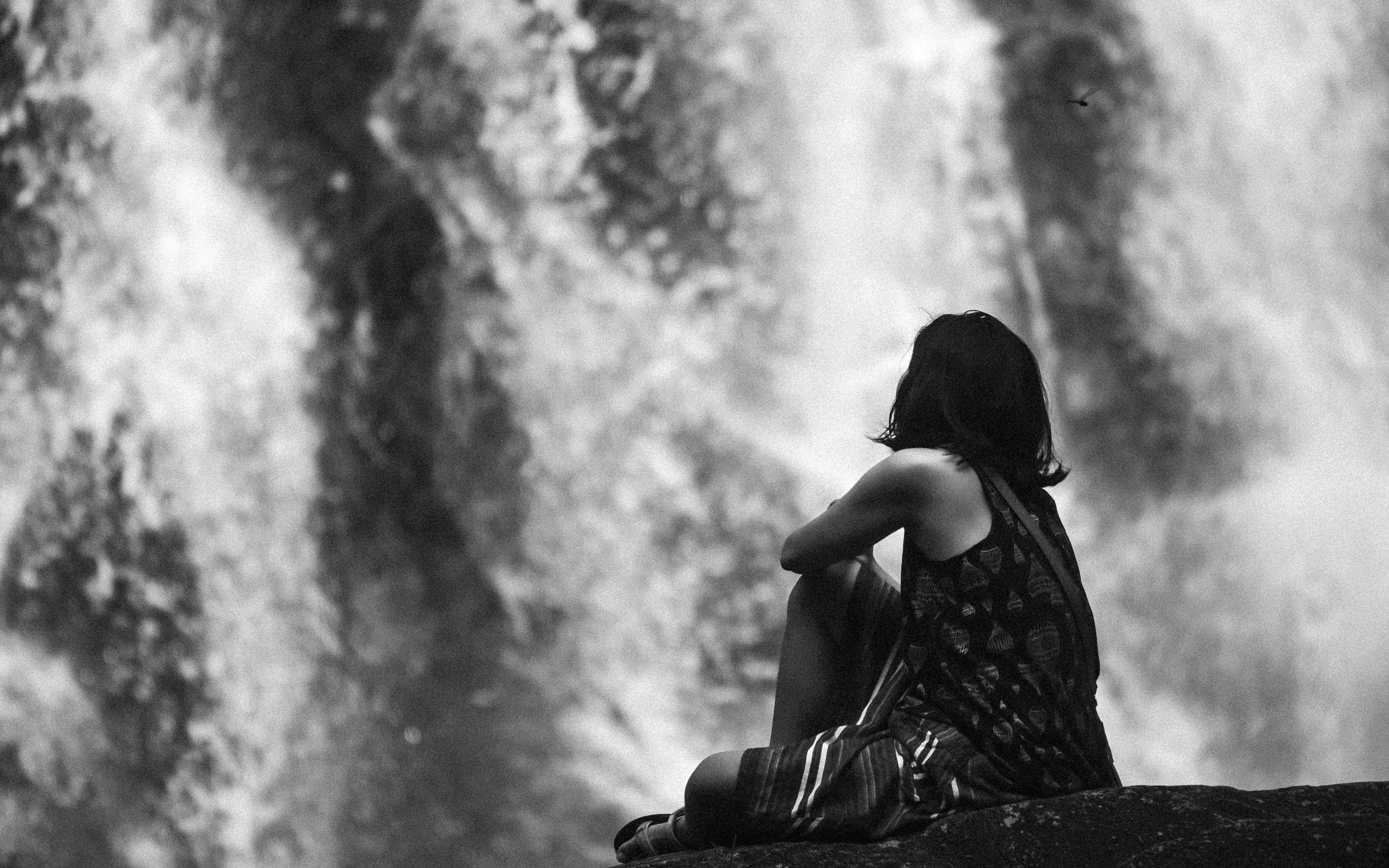 a woman sitting on a rock in front of a waterfall, Dragonfly.