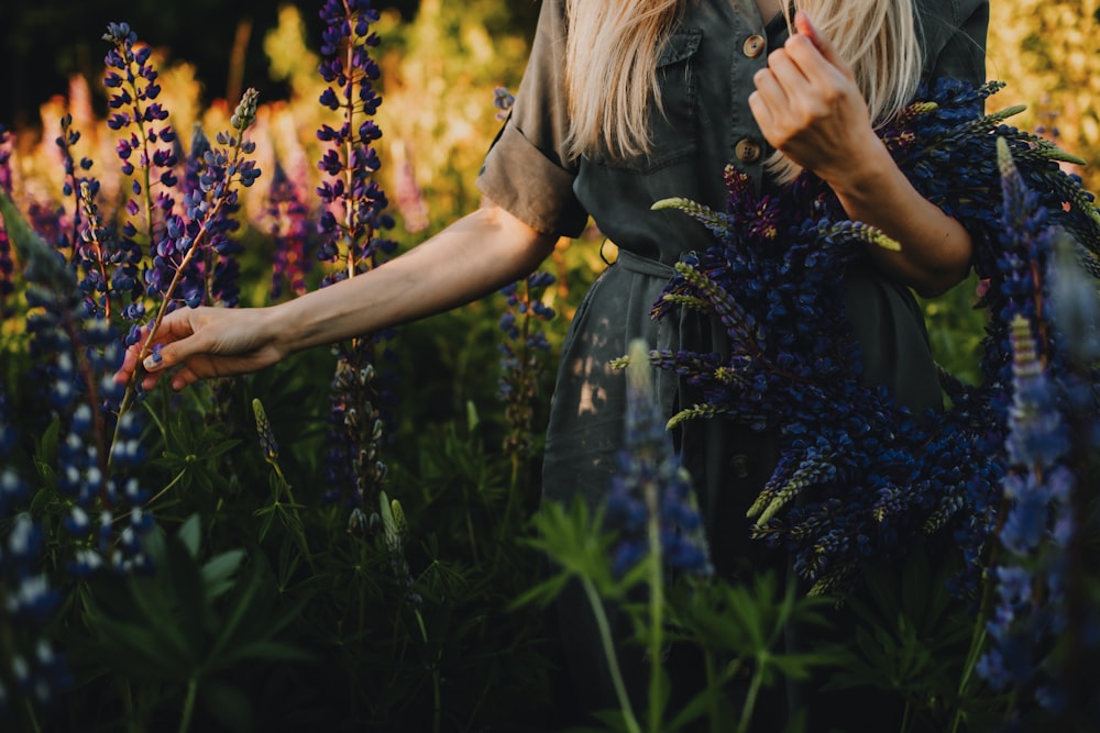 a woman standing in a field of purple flowers