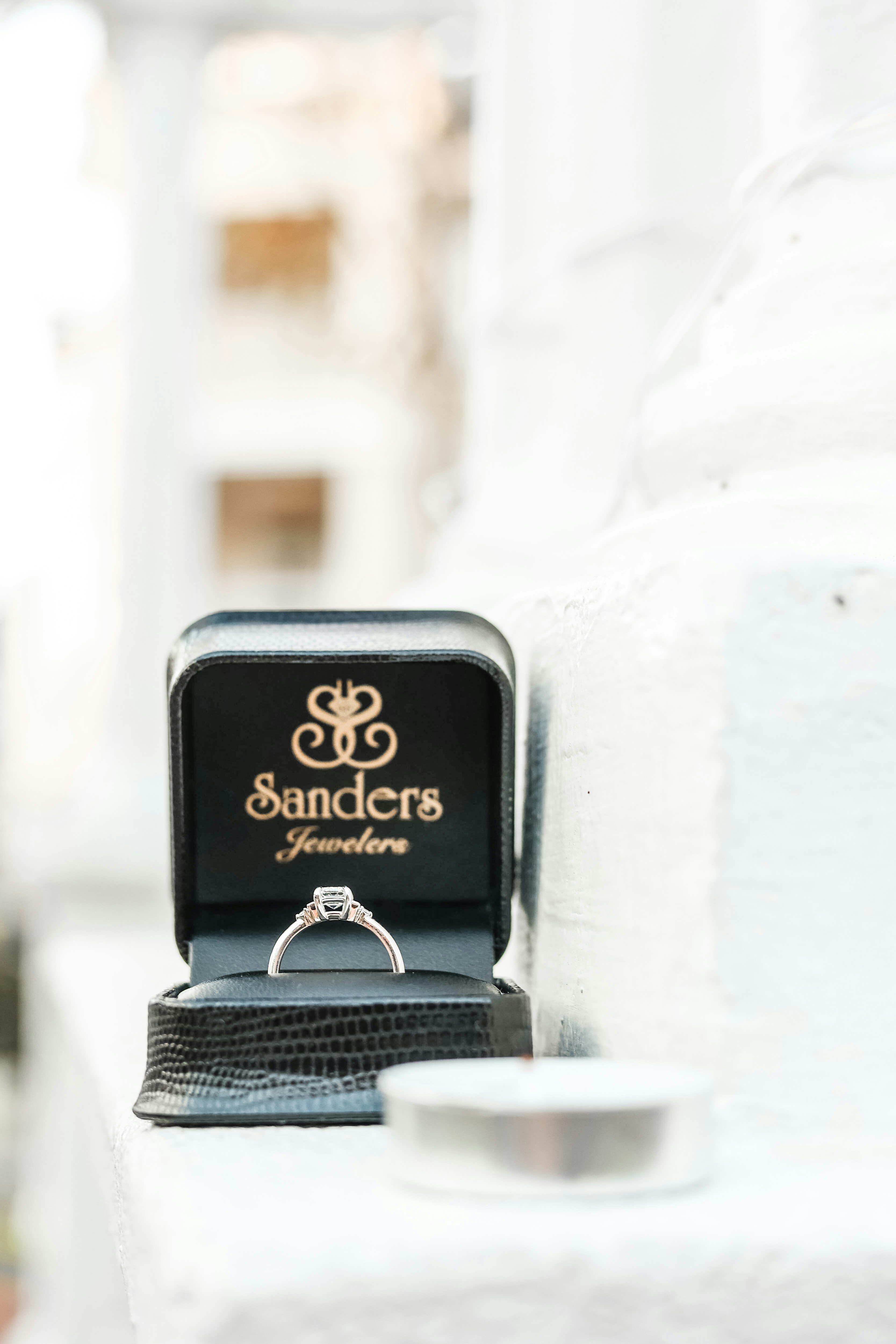 a ring sits in a box on a ledge