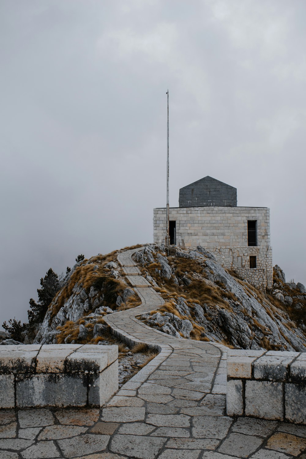 a stone path leading to a building on top of a hill