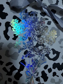 An elegant branded print display featuring refined metallic gold details on a black-and-white cow pattern.