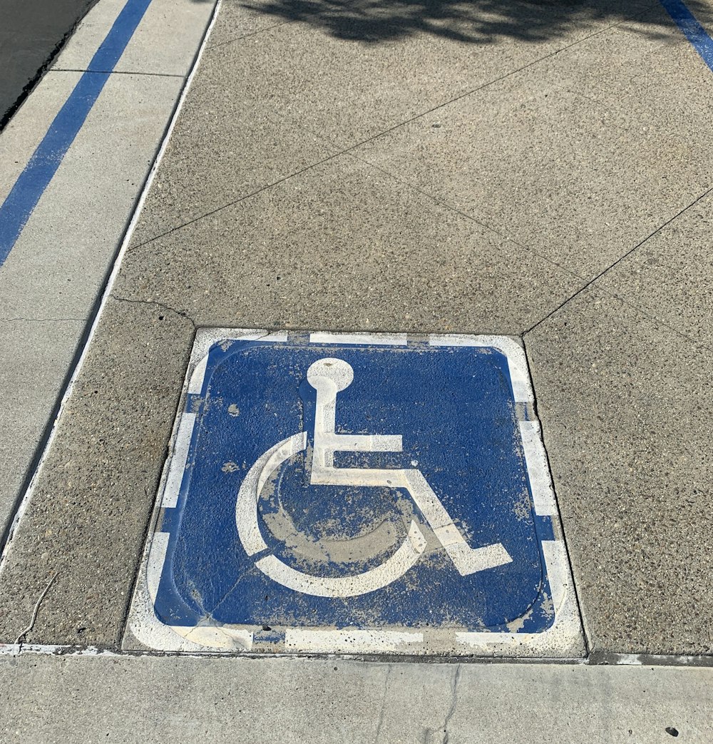 a handicap sign on the sidewalk of a city street