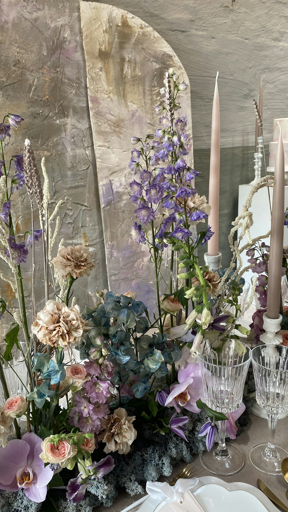 a table topped with a vase filled with purple flowers