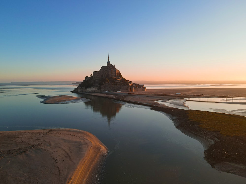 a castle sitting on top of a beach next to a body of water
