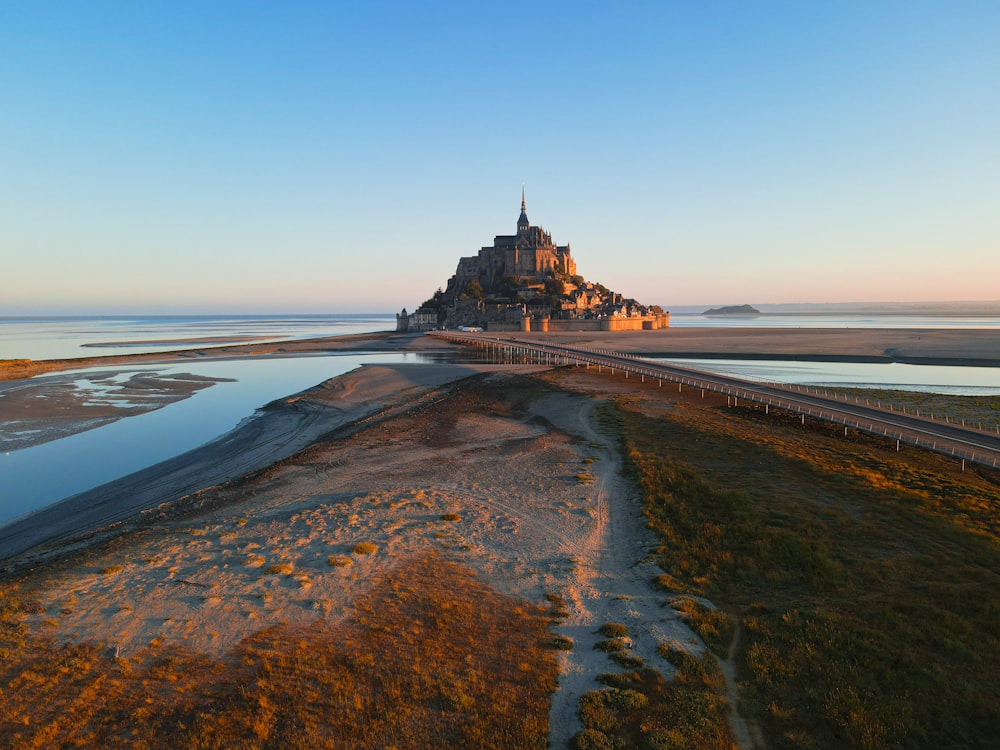 a large castle sitting on top of a beach next to a body of water