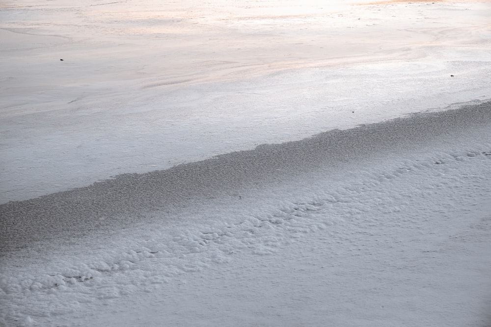 a person riding a snowboard down a snow covered slope