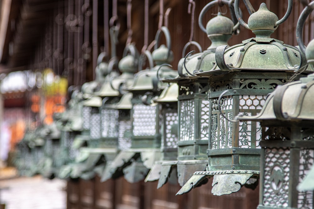 a row of metal lanterns hanging from a building