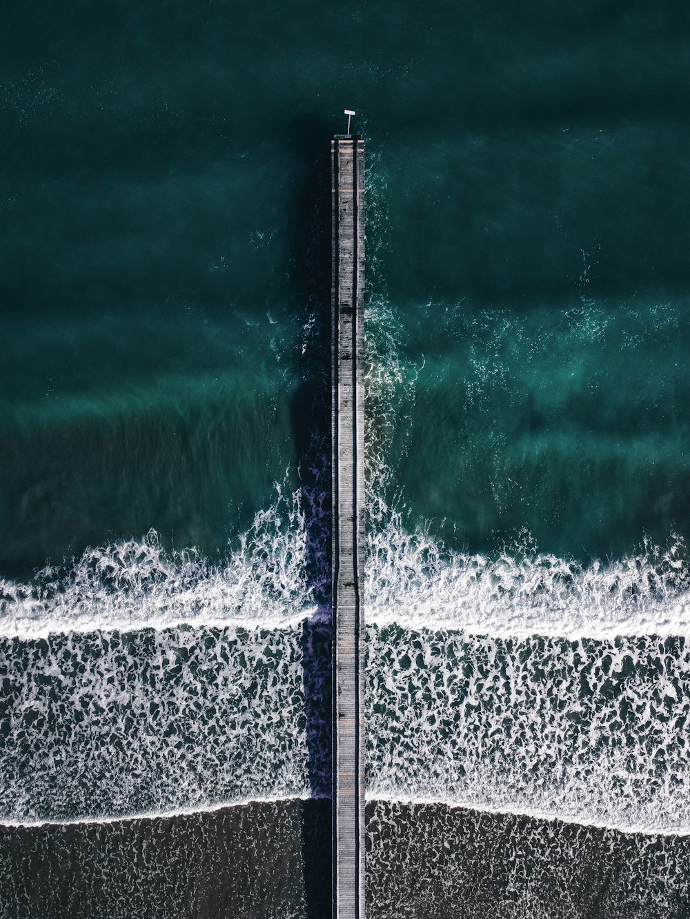 an aerial view of a pier and the ocean