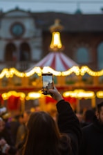 a person taking a picture of a carousel