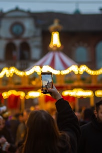 a person taking a picture of a carousel