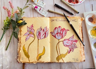 An open sketchbook with pencil drawings and notes on a wooden table.