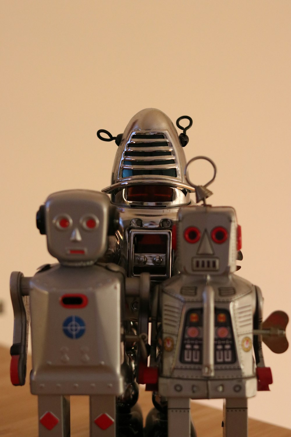 a couple of robot toys sitting on top of a wooden table