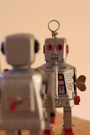 a couple of toy robots standing on top of a wooden table