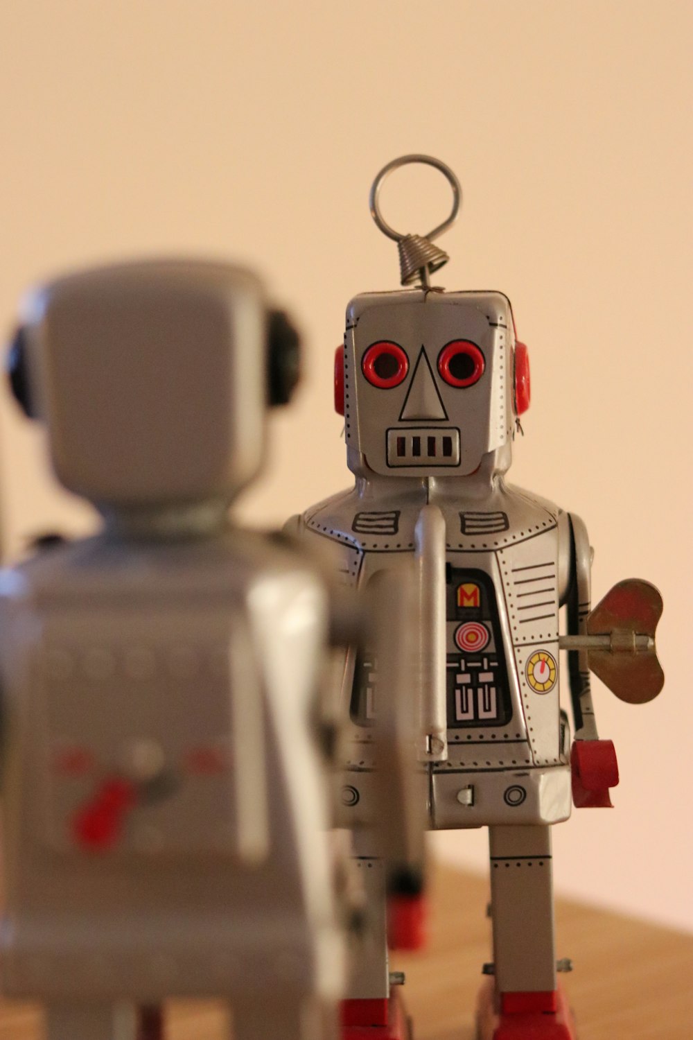 a couple of toy robots standing on top of a wooden table