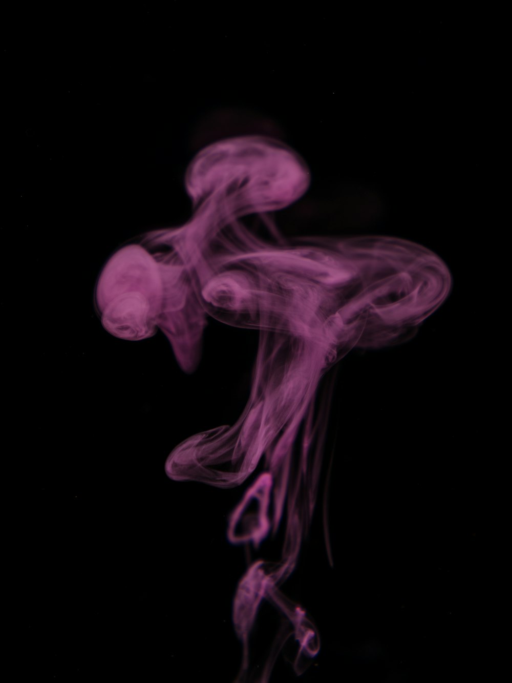 a purple smoke is in the air on a black background