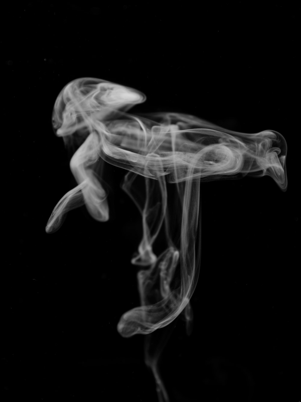 a black and white photo of smoke in the air