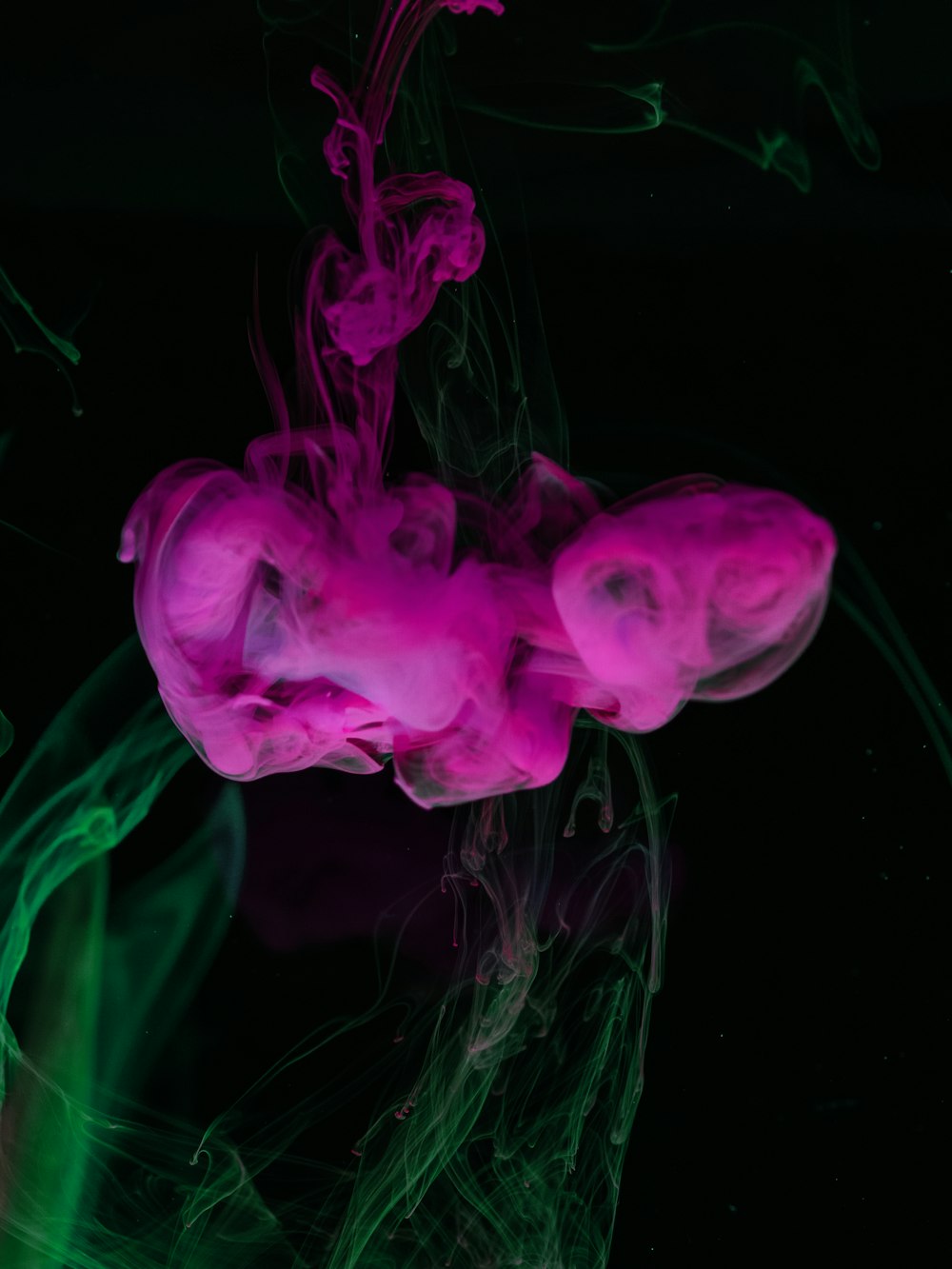 a pink and green substance floating in the air