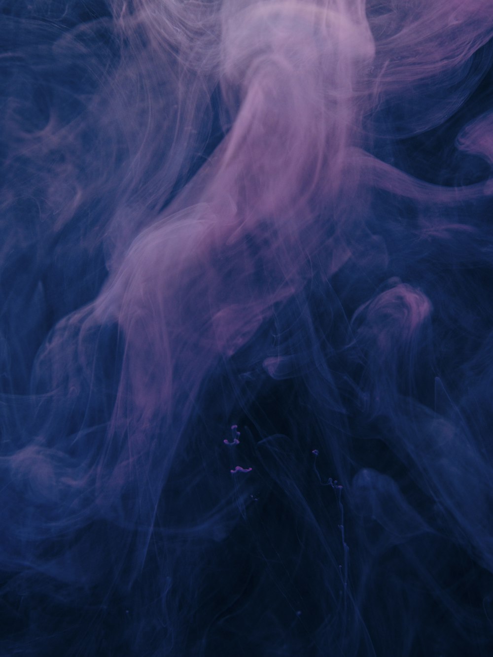 a blue and pink background with smoke coming out of it