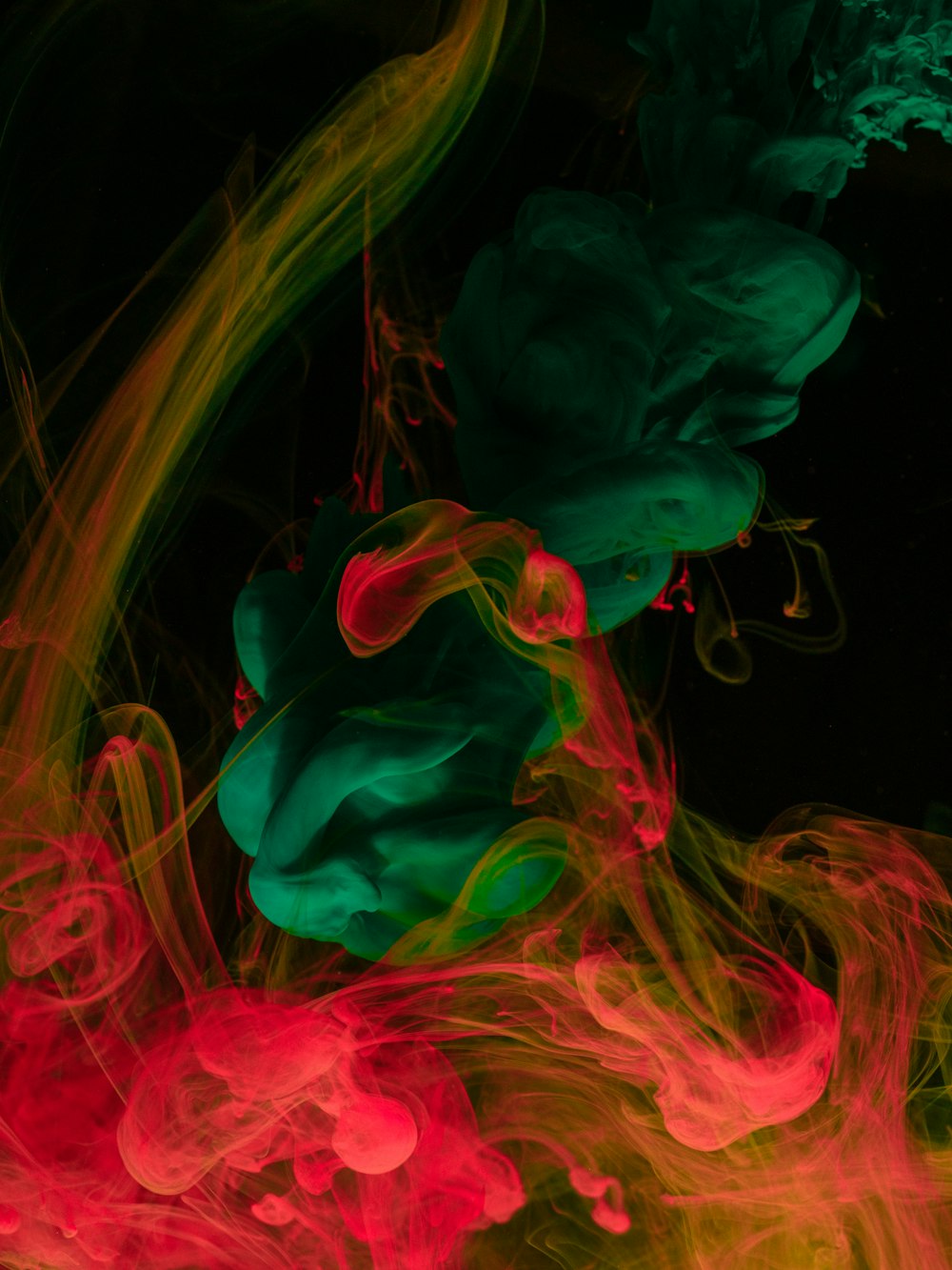 a bunch of different colored smoke on a black background