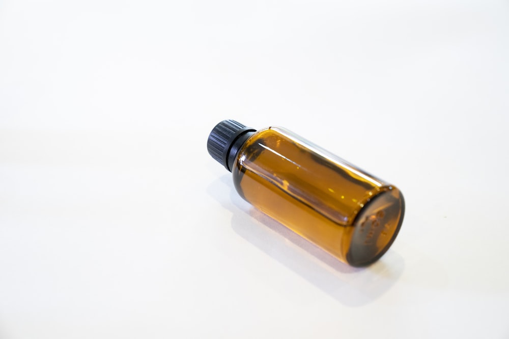a bottle of essential oils on a white surface