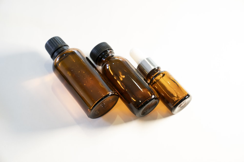 three bottles of essential oils on a white surface