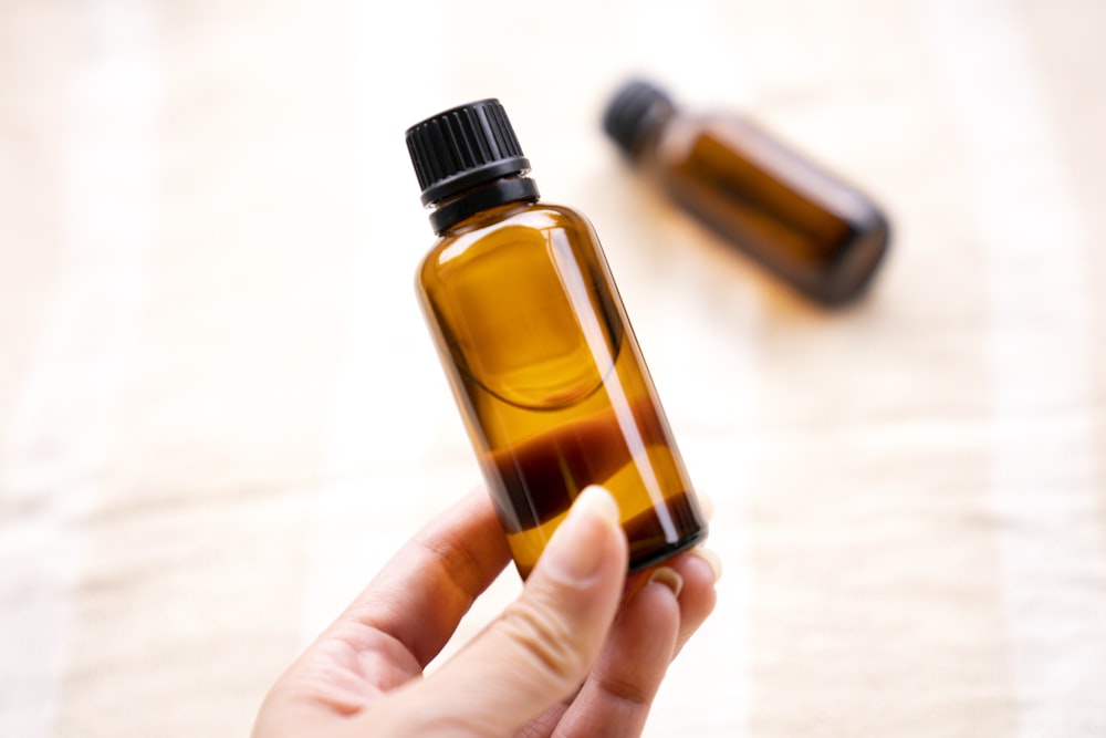 a person holding a bottle of essential oils